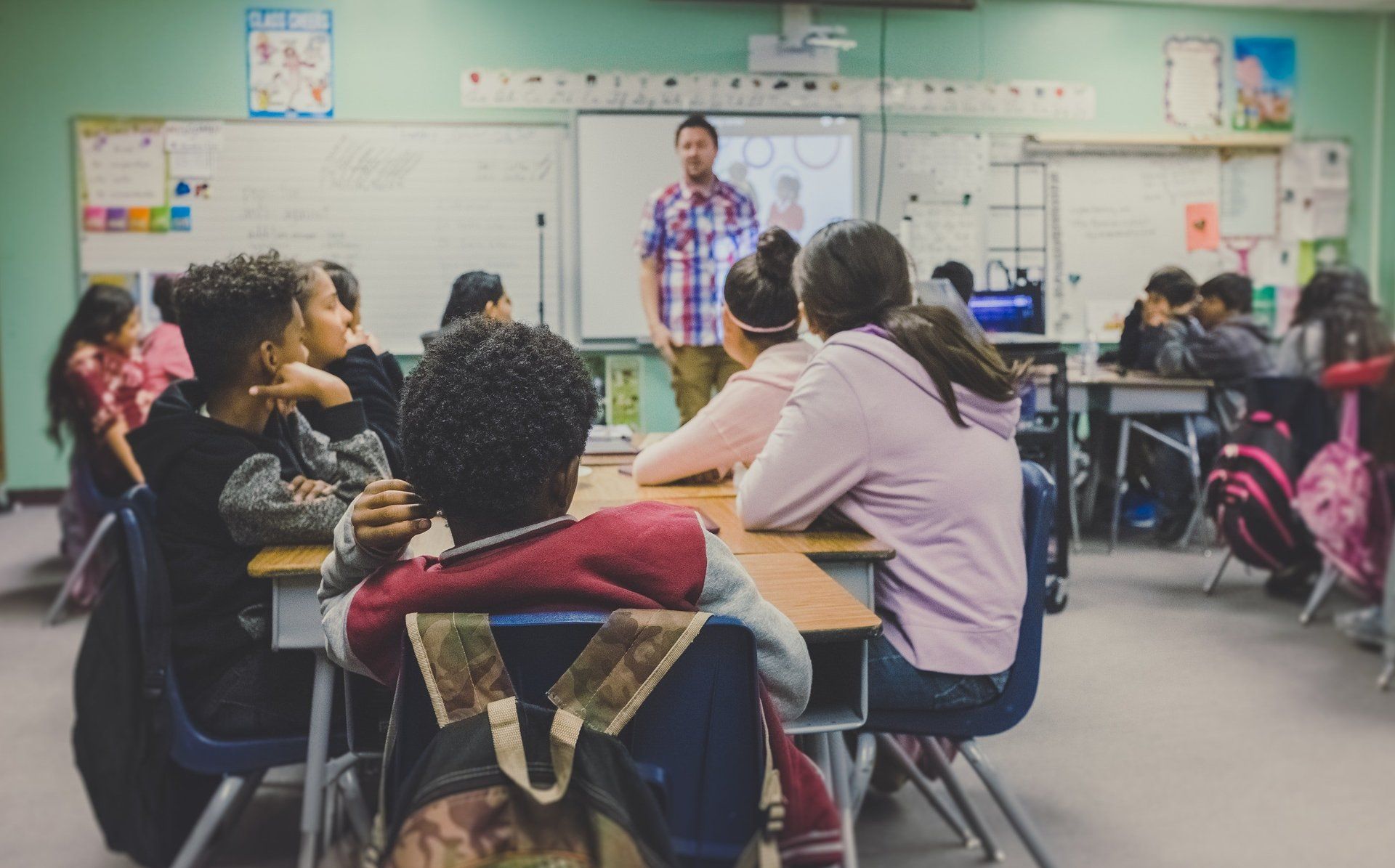 A teacher leading a discussion in a busy classroom of students
